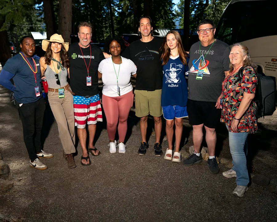 Camp Rennervation volunteers and visitors posing beside the foundation bus